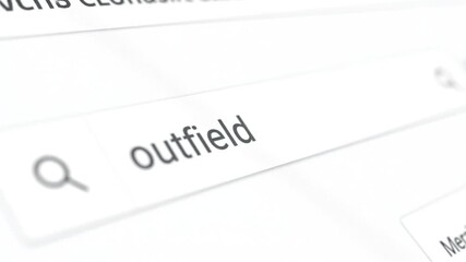 A digital screen displays a search bar with "outfield" typed in, next to a magnifying glass icon - Powered by Adobe