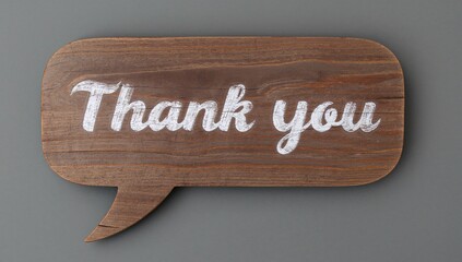 Thank You Note on a Chalkboard Designed Like a Speech Bubble, Set Against Rustic Wooden Background