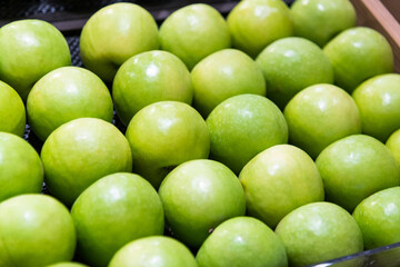Fresh green apples arranged neatly in the supermarket