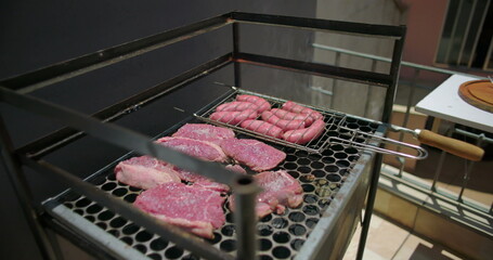 Grilled sausages and steak cooking on a rooftop barbecue grill, sizzling and ready for a summer...