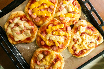 Homemade mini pizzas with sausages. Pastries. Bread. Dough.