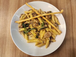 Penne pasta with white sauce, truffles and beef sausages at the pizzeria