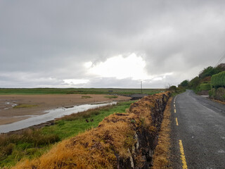 Fototapeta premium Single lane country road on the Dingle Peninsula in Ireland, along the Dingle Way hiking trail.