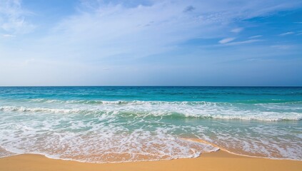 Obraz premium Coastal view of waves and sandy shore under a clear sky