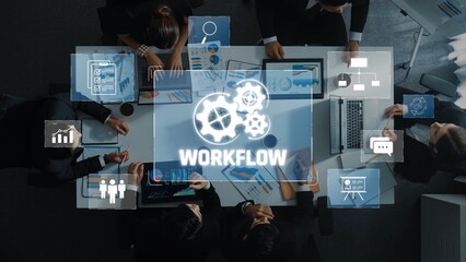 A diverse team engages in a business meeting while analyzing data on laptops and charts, with a workflow concept overlaid to emphasize collaboration and productivity. Raster