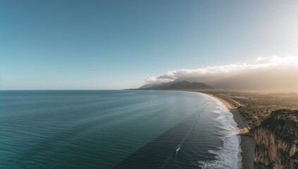 Ocean waves crashing near a rocky coastline under a clear sky