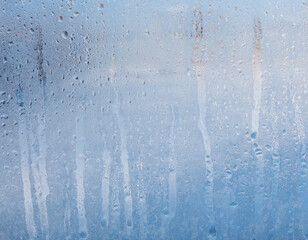 Frozen water drops on glass as an abstract background.
