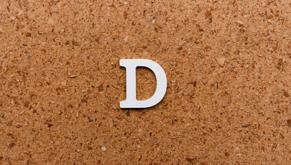 The letter D displayed on a corkboard alphabet set