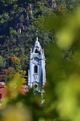 Dürnstein Kirchturm mit Weinblättern im Herbst, vertikal