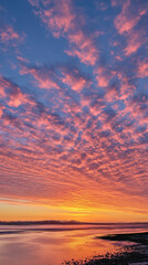 Fototapeta premium Vibrant sunset over calm water reflecting colorful clouds 