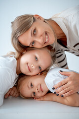 mother with children and daughters, maternal love and care, mother and child hug and kiss on a white isolated background, a family with two children