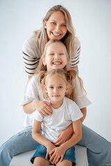 mother with children and daughters, maternal love and care, mother and child hug and kiss on a white isolated background, a family with two children