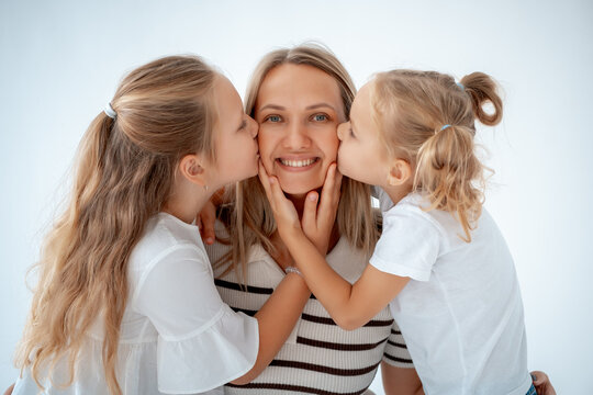 mother with children and daughters, maternal love and care, mother and child hug and kiss on a white isolated background, a family with two children