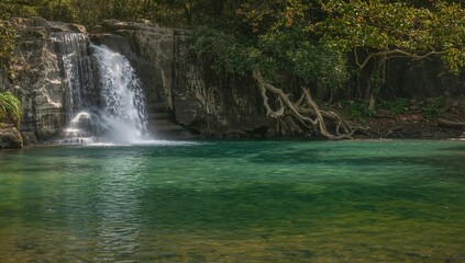 Fototapeta premium Cascade And Turquoise Pool, Water Textures Reflecting Light, Foliage And Natural Rock Formations.