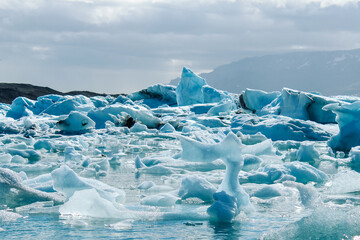 Intricate blue ice patterns and textures on floating icebergs in Jökulsárlón glacier lagoon, Iceland