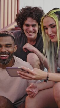 Modern online communication. Group of young friends with unusual appearance watching video or video calling on cellphone