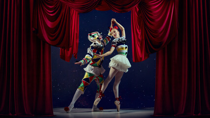 Carnival dance. Mime and ballerina holding hands under red curtain in stage spotlight. Concept of...