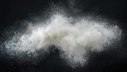 Slow-motion explosion of fine white dust on a dark backdrop