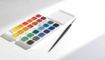 Complete set of watercolors and brush on a white surface