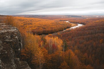Obraz premium Fall scenery from a high vantage point overlooking a forested area.