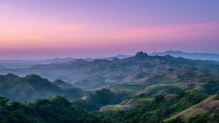 Fototapeta premium Rolling verdant hills stretch across the landscape beneath a vibrant pink and purple twilight sky