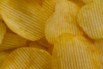 Potato chips in a plate close-up as background