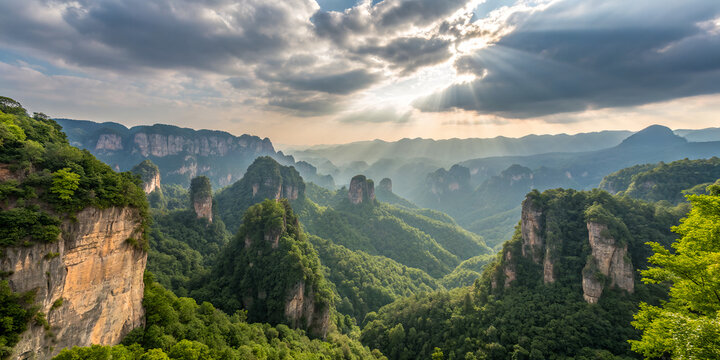 Misty mountain peaks towering above lush green forested valley scenery