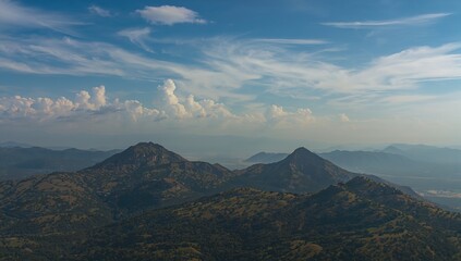 Naklejka premium Mountain Peaks Under a Vibrant Blue Sky with Clouds