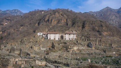 Obraz premium Picturesque ruins of a deserted settlement left behind by a landslide, showcasing ancient architecture and natural erosion