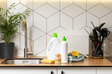 Eco cleaning products against the background of the kitchen. Eco-friendly home cleaning. A bottle of natural detergent surfaces, eco brushes, sponges, and rags. Cleaner concept.Cleaning supplies.