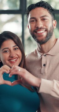 Home, face and happy couple with hand heart for love, commitment and connection in relationship. Portrait, man and woman gesture for care in apartment, support and affection for marriage bonding.