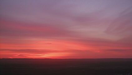 Fototapeta premium The horizon glows with shades of pink and orange as the sun sets, marking the close of a stunning day.