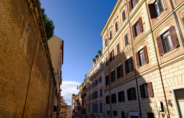 low angle shot of a narrow street in the old town of Rome, Italy, lined by classical residential buildings