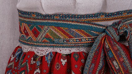 Close-up of a vibrant traditional woven belt featuring intricate patterns and textures used in cultural celebrations.
