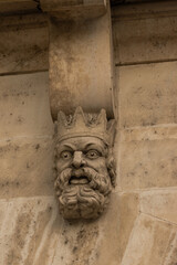 ChatGPT сказал:

Stone gargoyle sculpture on a historic building facade against a clear blue sky. Detail of Gothic architecture symbolizing art, mythology, and medieval craftsmanship.