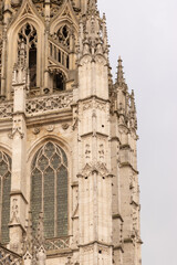 Obraz premium View of Rouen Cathedral rising above narrow old streets. Historic Gothic architecture in Normandy, France, captured in soft daylight, showcasing medieval charm and cultural heritage.
