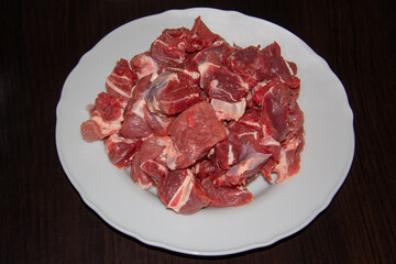 Piece of raw beef on a wooden cutting board.