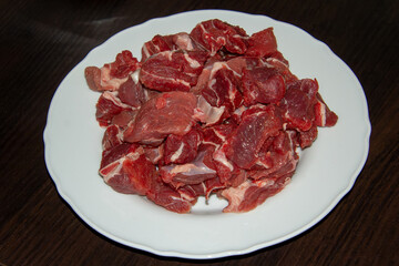 Piece of raw beef on a wooden cutting board.