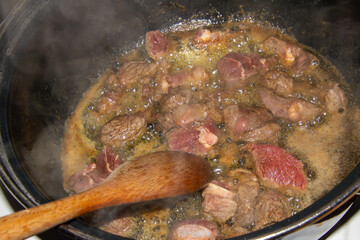 Preparing a hash with onions and stew beef.