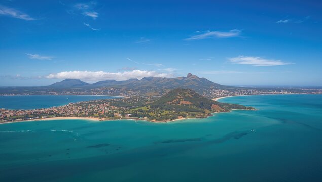 Aerial view of a coastal town with a distant mountain peak