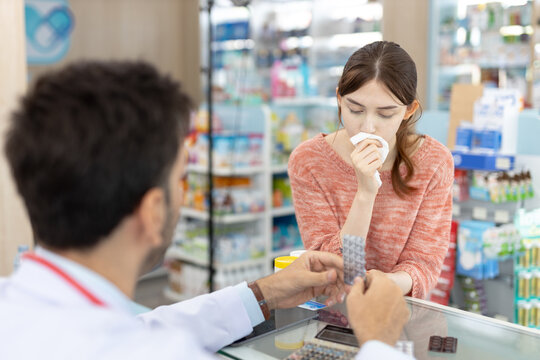 Sick women consulting with pharmacist in pharmacy, holding tissue and receiving medication advice, representing cold and flu treatment, pharmaceutical care, patient support and healthcare service. - Powered by Adobe