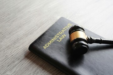 A gavel on a book titled ADMINISTRATIVE LAW. Justice, regulation, and the legal system concept.