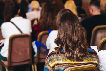 Female audience at the symposyum meeting, participants attendees in conference room hall listens to...