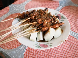 Sate Kelinci or rabbit satay served with lontong rice cake