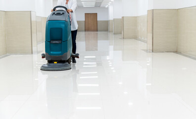 Woman using scrubber machine wash the floor