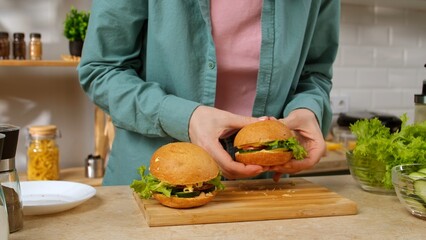 Close up of hands making fresh vegetable sandwiches on a wooden board. Preparing a healthy...