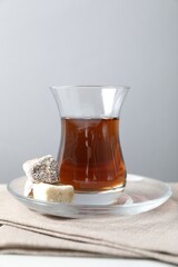 Traditional Turkish tea served with sweets on white table, closeup
