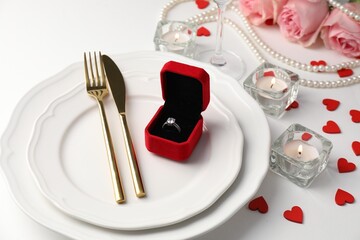 Beautiful table setting for romantic dinner, box with engagement ring and roses on white background, closeup