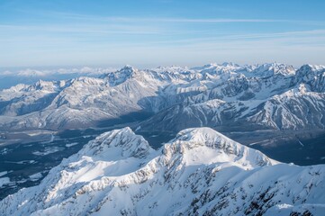 Naklejka premium Snow-covered peaks in a European mountain range, winter landscape, alpine sports, mountain summits, adventure sports spot, winter vacation destination, mountainous scenery