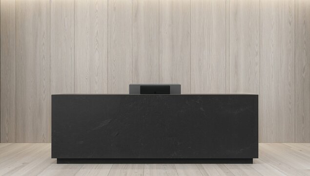 Contemporary dark concrete reception counter seen from the front with a laptop against a light wooden backdrop